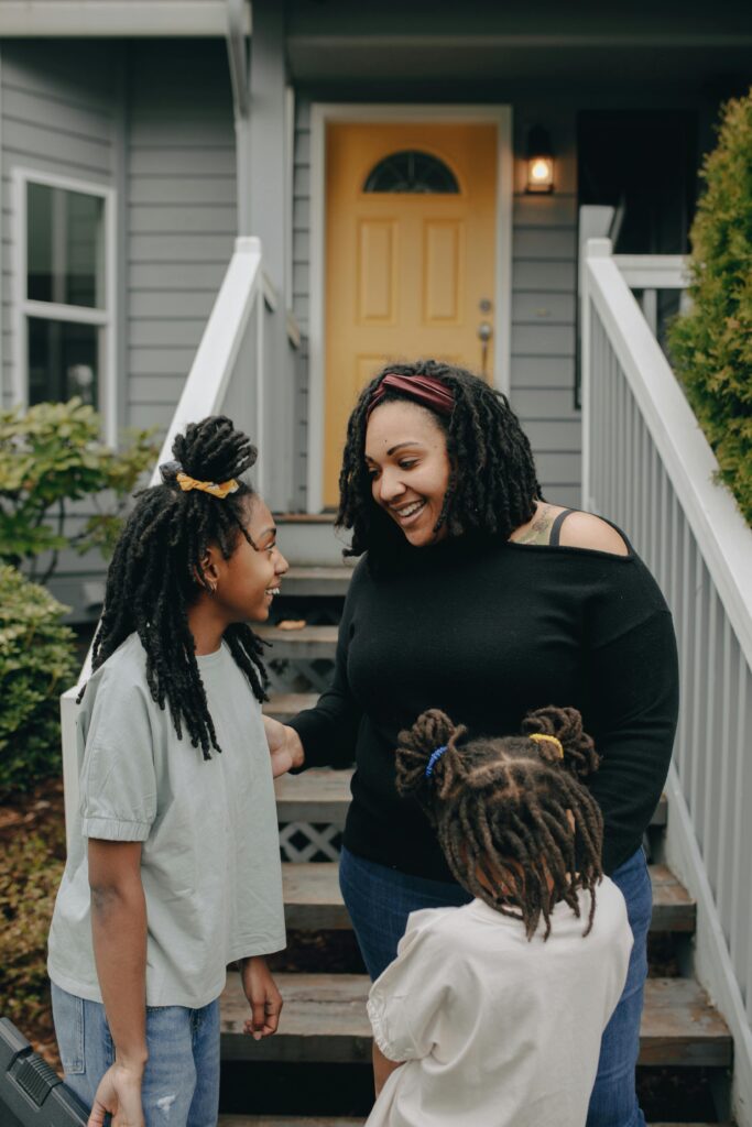 A mother and her daughters enjoying a cheerful moment together outdoors.