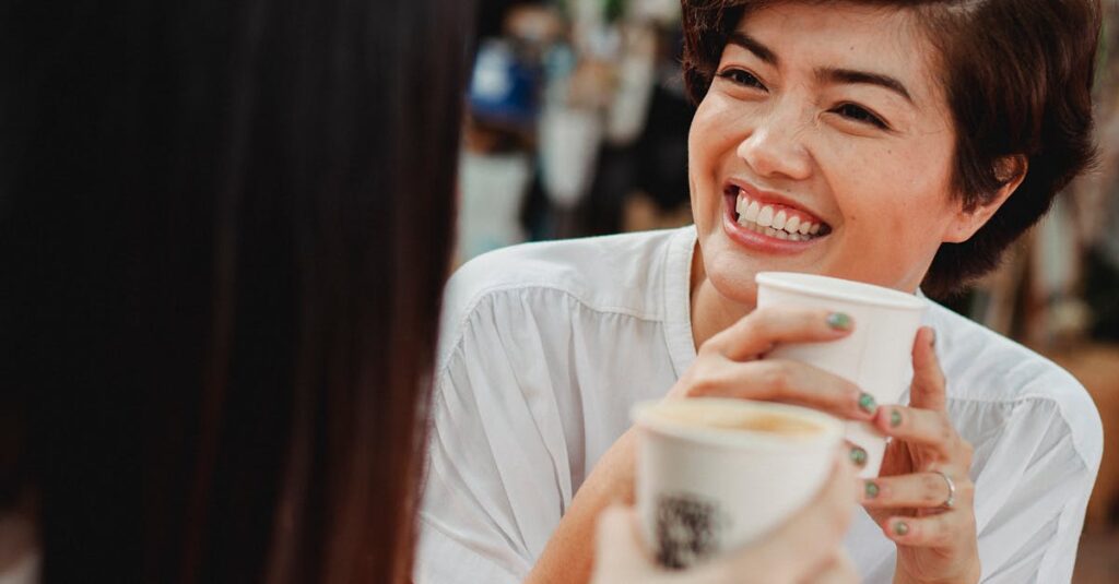 Two women enjoying a joyful coffee conversation outdoors at a café