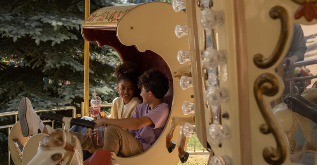 Young couple riding a carousel enjoying a warm summer day at the amusement park.