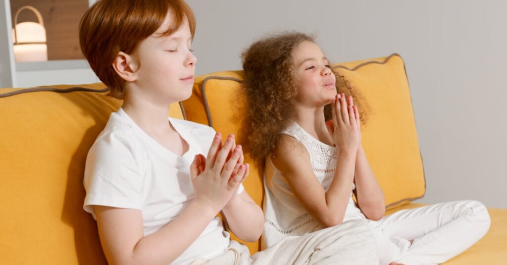 Two kids peacefully meditating on a yellow sofa indoors, focusing on relaxation.