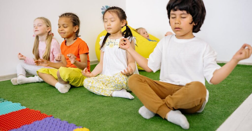 Group of diverse young children meditating in yoga poses on a green mat indoors.